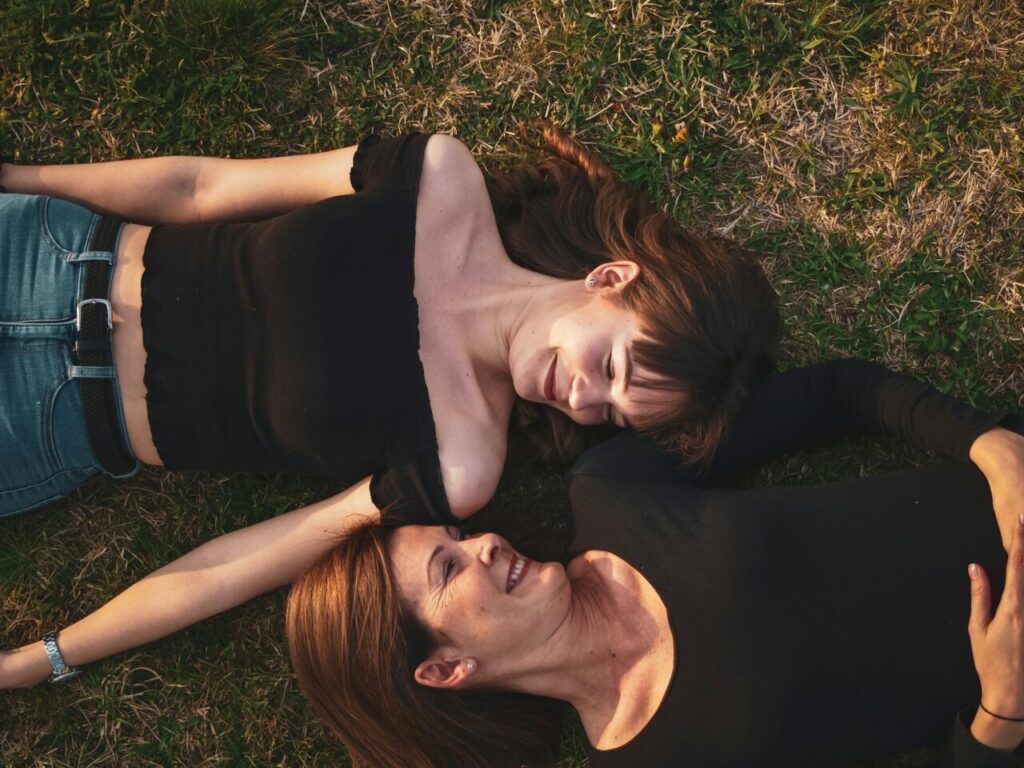 two women lying on grass, discussing psilocybin mushroom benefits for menopause